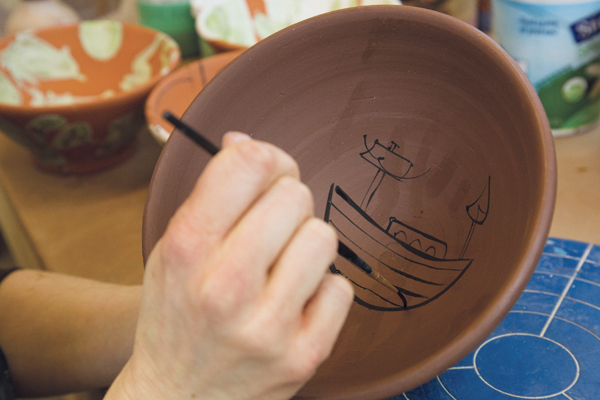 1 Throw a wide bowl and smooth the interior, then trim a deep foot. Paint with black underglaze at the leather-hard stage for longer brush strokes. Start by painting an image anywhere on the bowl with a long bristled brush.