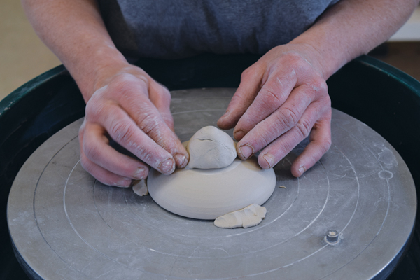 5 Trim excess clay from the top of the lid. Score and slip the center, add a small cone of clay, then shape it into a knob.