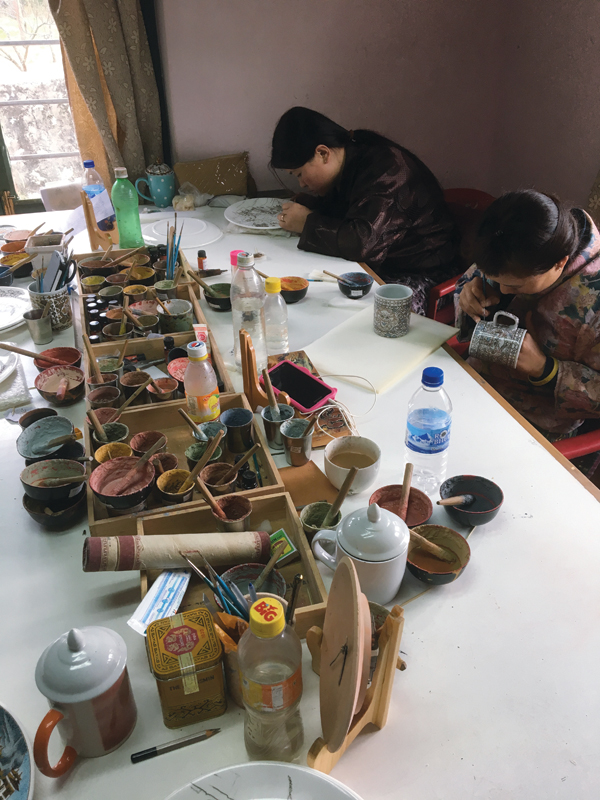6 Women paint on overglaze designs in Yangphel’s workroom. 