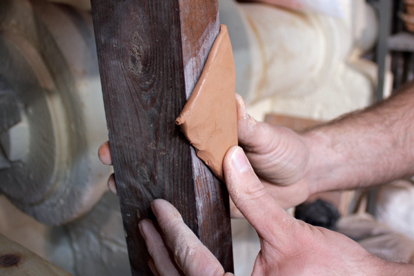 17 Either by sketching directly on clay or with paper templates, cut out a spout, then crease it by pushing it against the edge of a 2×4 board.