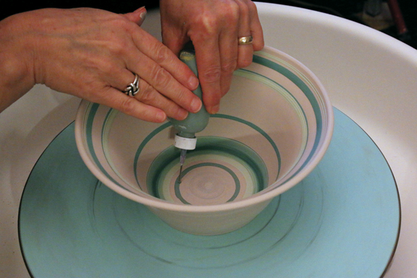 1 Center and throw a bowl on a bat on the wheel. Divide up the space with banding.