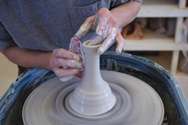 3 Shape the handle by pulling and collaring, using a rib to smooth and refine the form.