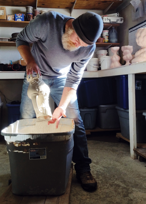 13 Botbyl dipping a bisqued pitcher in crackle slip. Photo: Andrew Clark.