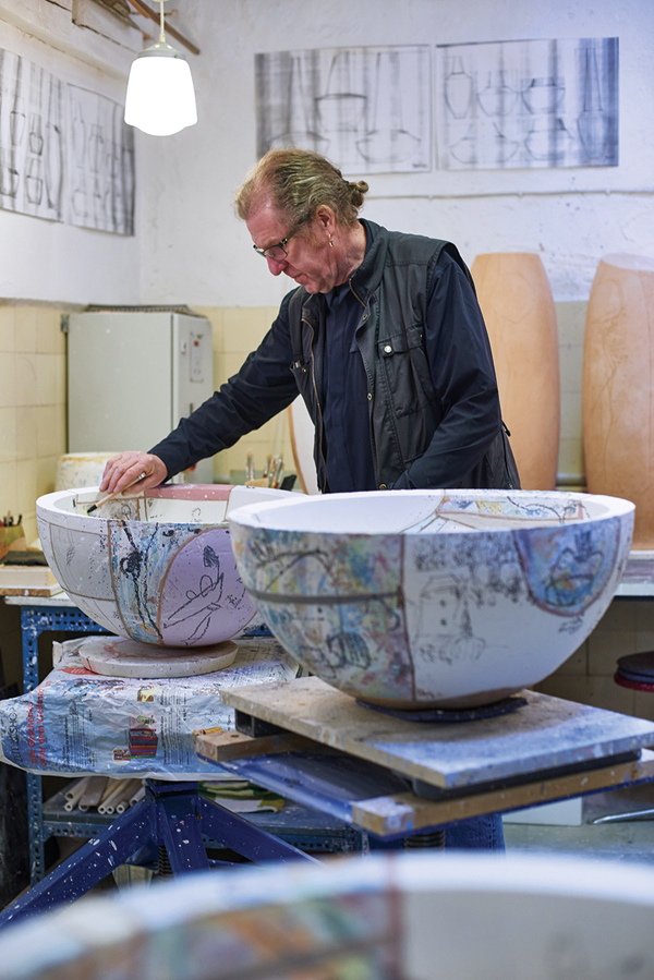 1 Christoph Hasenberg painting and drawing on big bowls.