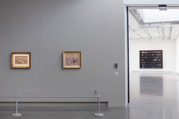 4 Left: Giorgio Morandi’s Natura morta, 15¾ in. (40 cm) in width, oil on canvas, 1956. Courtesy of Istituzione Bologna Musei|Museo Morandi. Right: Giorgio Morandi’s Natura morta, 15¾ in. (40 cm) in width, oil on canvas, 1957. Background: Edmund de Waal’s the reader, 8 ft. 5 in. (2.6 m) in width, 56 porcelain vessels, 13 alabaster blocks, and 5 Cor-ten steel blocks in a wood and Plexiglas vitrine, 2016. Photo: Jean-Baptiste Beranger, Artipelag.