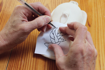 8 Position the image to the clay and use a pen to trace over the lines so the graphite transfers to the clay.