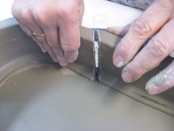 5 Cut a beveled edge on both joining pieces of the wall, score, and add slip before attaching together.