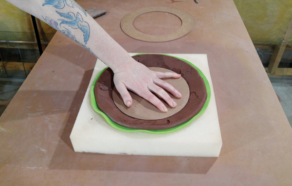 9 Removing the rim and pressing the center firmly into the clay.