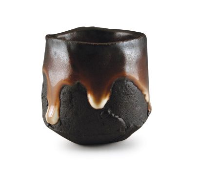 21 Lucien Koonce’s black clay sake cup, 2½ in. (6 cm) in diameter, handformed and hollowed black stoneware clay, shino glaze, natural ash glaze, wood fired to cone 12.