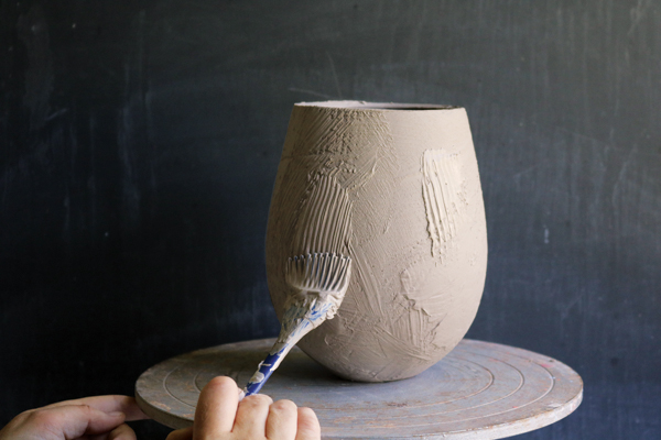 4 Apply white slip onto the thrown vessel with a silicon pastry brush.