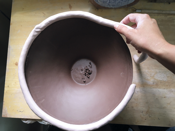 4 Lay a coil of contrasting clay on top of the wedge-shaped, moistened rim.