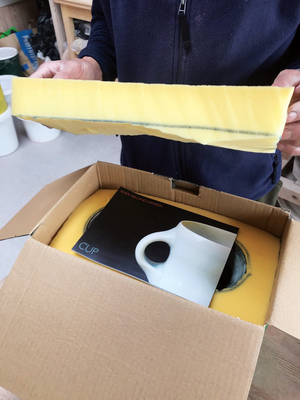 7 Adding the top layer of two-inch-thick foam to protect the tops of the pieces, prior to sealing up the box.