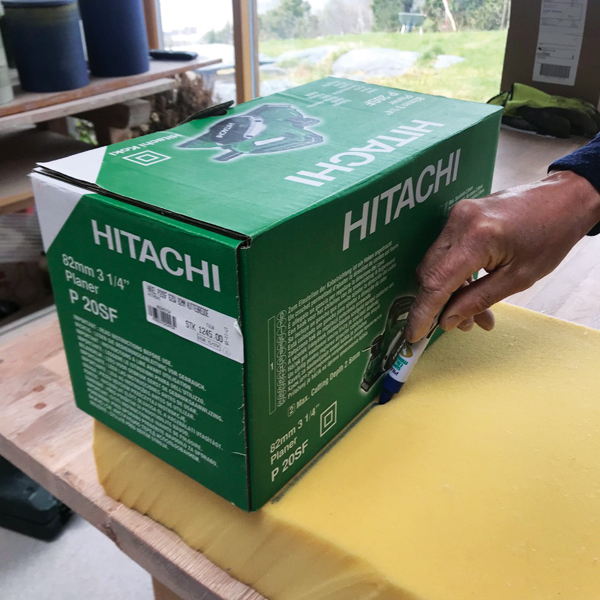 1 Tracing the outline of a cardboard box with a felt pen onto upholstery foam.