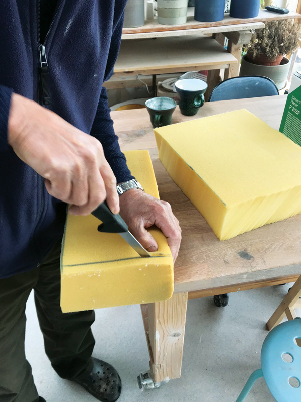 2 Cutting the foam to fit into the box using a long, narrow-bladed sharp knife. 