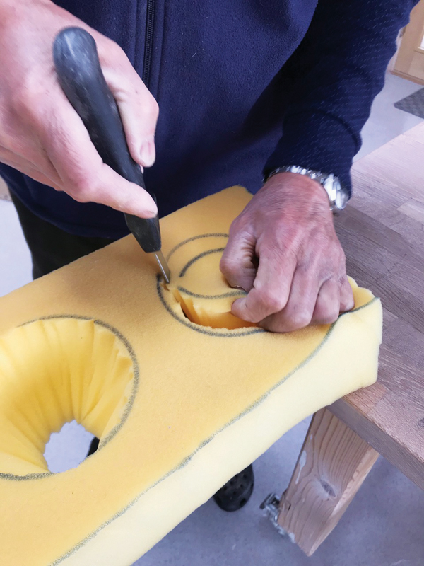 5 Cutting out the foam, following the outline as well as angling the knife so the cut tapers inward to follow the contours of the mug.