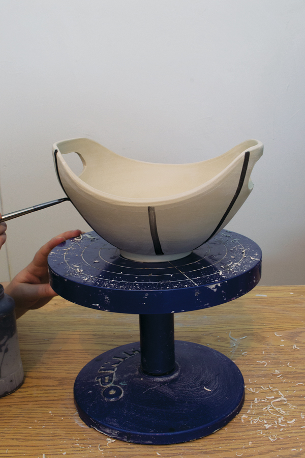 6 Paint vertical lines of underglaze on the stiff leather-hard bowl, starting at the midpoints and corners first.