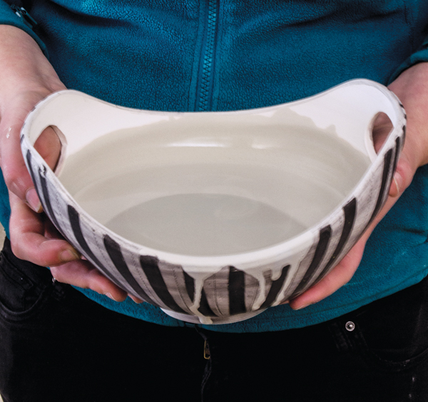 11 Glaze the inside of the bowl by filling to just below the lower rim and pouring out the higher sides. Wipe away the excess glaze, leaving the rim unglazed.