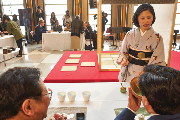 6 Shoko Aono (foreground, right) and Tsubaki (background, center) speaking to participants learning to make matcha and sencha tea. Photo: Douglas Dubler. 