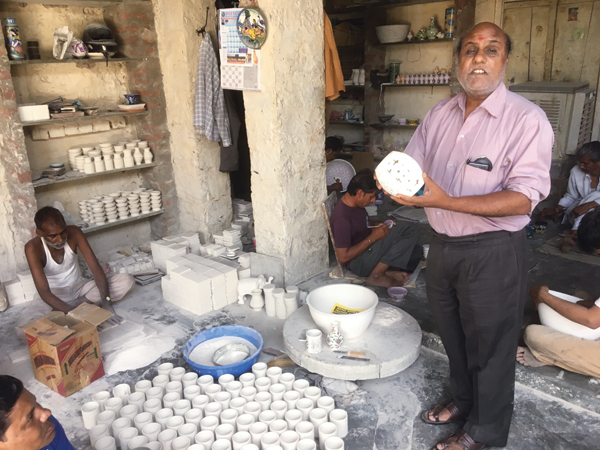 3 Factory owner Kailash Doraya holds an example of what his factory produces. 