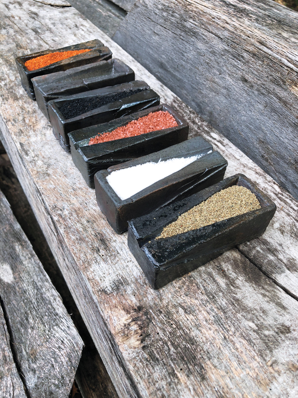 Spice servers filled with (left to right): Piment d’Espelette, empty, nigella seeds, sriracha sea salt, kosher salt, and celery seeds.