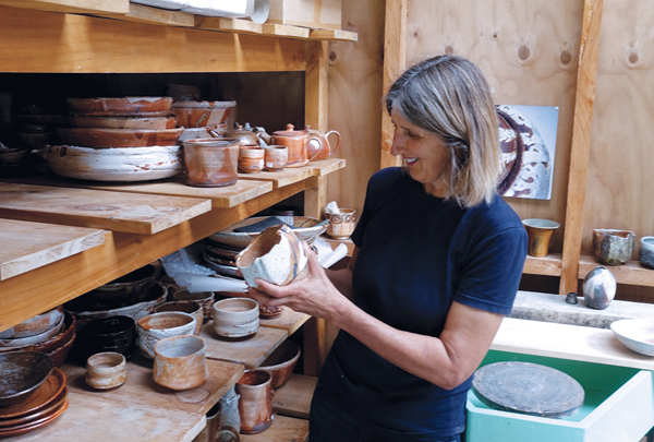 2 Elena Renker in her studio with some of her fired ceramic pieces.