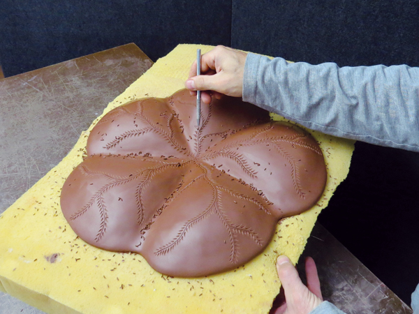 8 While it’s still supported by the foam, incise and carve designs onto the bottom of the leather-hard platter.