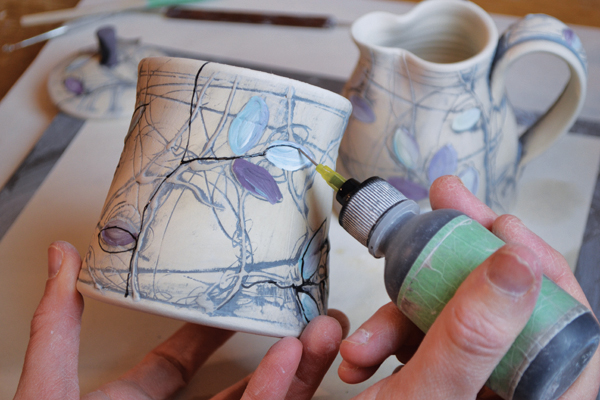 13 Trail fine lines of black underglaze to accentuate certain parts of the drawing.