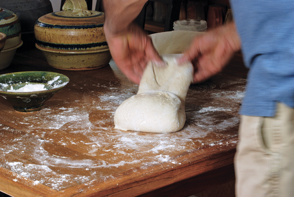 14 Lightly dust the ball with flour, then stretch and fold the dough over itself.