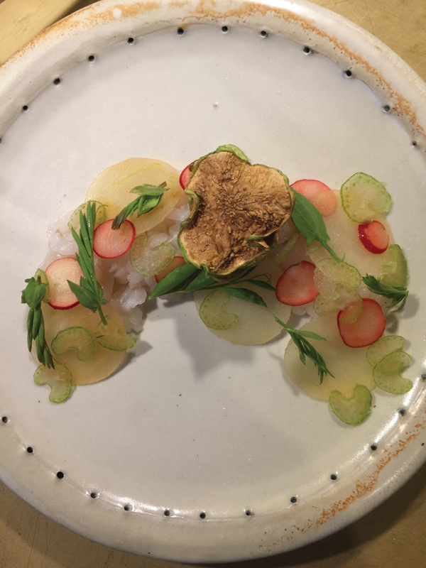 1 Laurel MacDuffie's plate, stoneware, 10 in. (25 cm) in diameter, salt fired to cone 10, 2017. Topped with gray sole crudo with lemon-verbena infused vegetables.