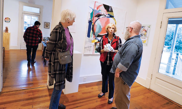 6 Artist Kristy Hughes’ opening reception at Plough Gallery, patrons and Mark Errol discussing the work, 2018. Photo: Glenn Josey.
