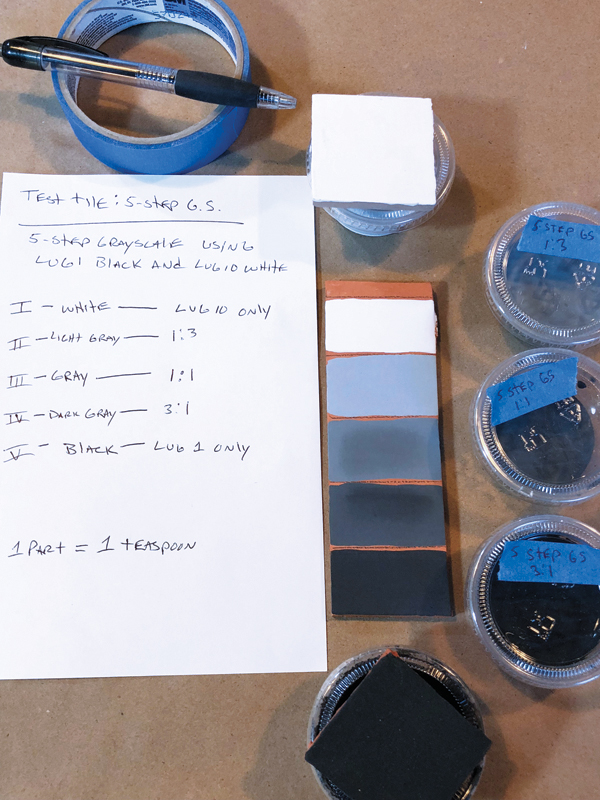 5 Grayscale mixed with AMACO LUG Black and LUG White, brushed on earthenware test tile. Amounts are recorded in a notebook using the parts method for mixing. Each mix is in its own small container and labeled.
