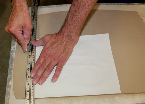 1 Cutting a right angle on the slab using a piece of paper as a guide.
