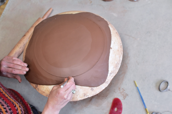 1 With your mold centered on a banding wheel, hold your knife steady to mark and cut an even circle.