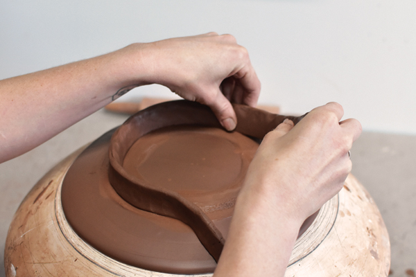 3 Score the foot ring and attach it to the plate, pressing firmly to ensure a good connection between the two.