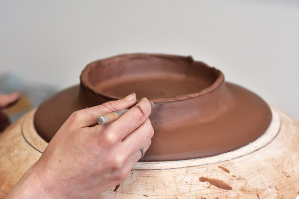 6 Trim and level the foot ring by holding the X-Acto knife steady and turning the banding wheel. Refine the rim edge.