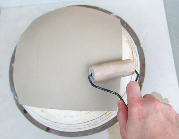 7 Use the pony roller to gently shape the slab to the plaster bowl form.