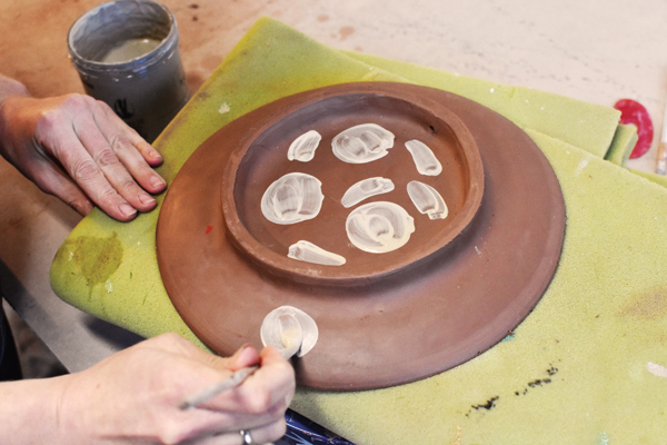 10 Flip your plate over onto foam, and paint white slip silhouettes in a pattern.