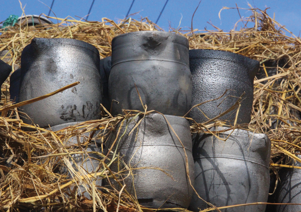 10 Spouted jugs, also for cooking herbal medicines, packed in straw ready to be transported to market. Apparent are variations in silvery residue.