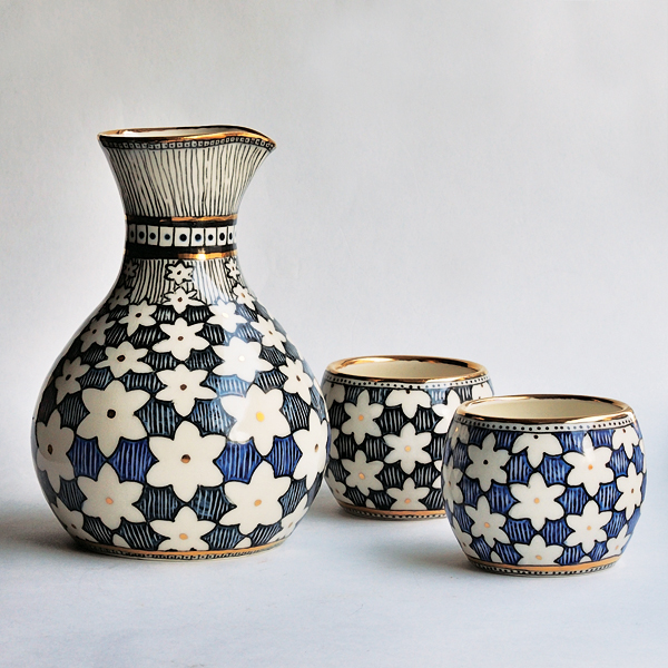 4 Tanya Everard’s black and blue sake vessel with two cups, to 5¼ in. (13 cm) in height, porcelain, slip-trailed underglaze, sgraffito, glaze, fired to cone 6 in an electric kiln, gold luster. 