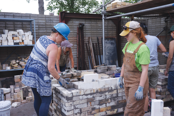 3 Donna Garofalo (left), Diane Laluk (rear, middle), and Emily Wolverton (right) mortaring the bricks for the firebox.