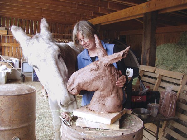 Participant with the donkey model at the Taos Art School Donkey Sculpture Workshop in Taos, New Mexico. 