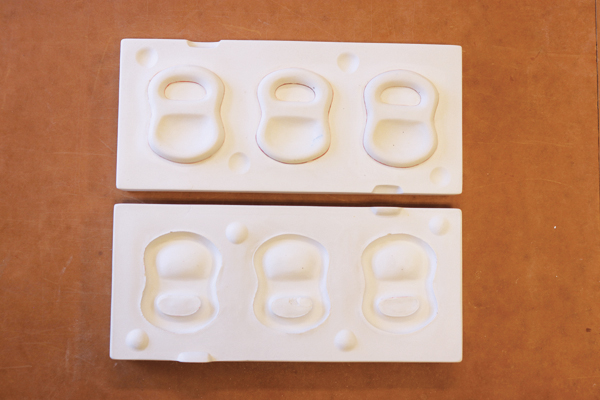 4 Solid cast mold for slip casting test tiles. The holes for pouring the slip are located in the half of the mold under the test tiles.