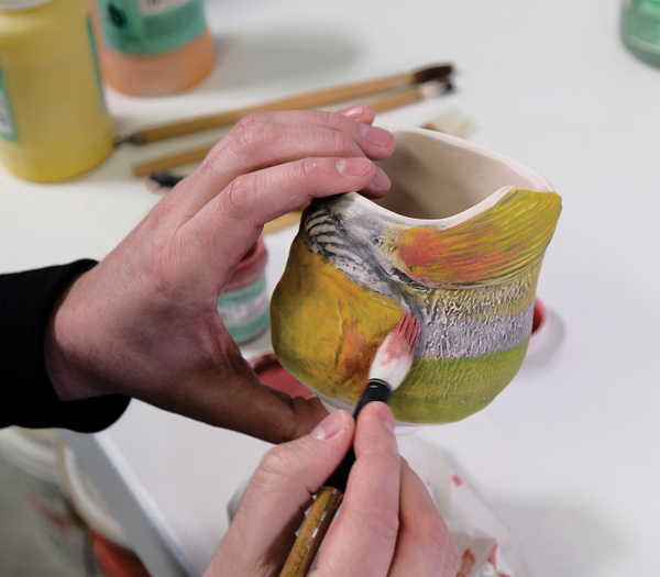 4 Continue layering by applying red underglaze using a dry-brush technique.