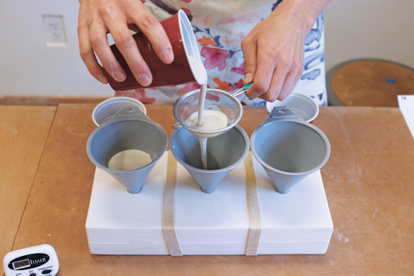 6 Pouring three different colored slips into the two-part chain mold to create test tiles.