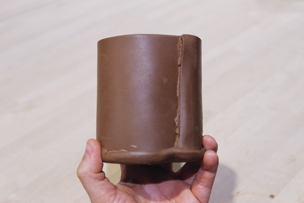 3 Attach a round slab to the bottom of the cylinder and smooth the edges.