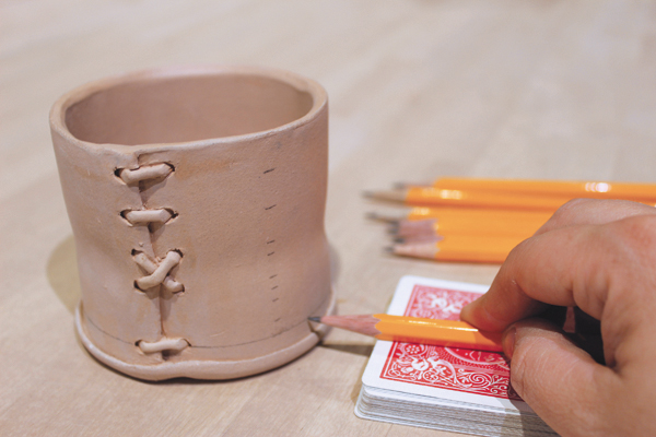 8 Hold the pencil steady against a deck of playing cards or similar support and turn the cup to get nice clean horizontal lines.