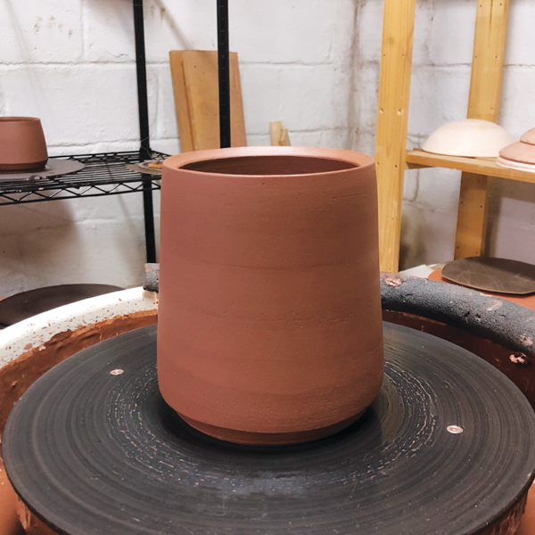 1 Throw a tall, wide cylinder on the wheel to form the body of the jar.