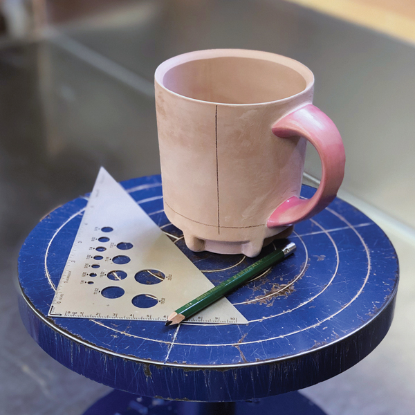 1 Draw several guidelines on the bone-dry, waxed mug for placing vinyl stickers.