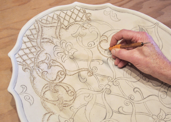 2 Sgraffito lines are drawn through the slip using a pointed sgraffito tool. 