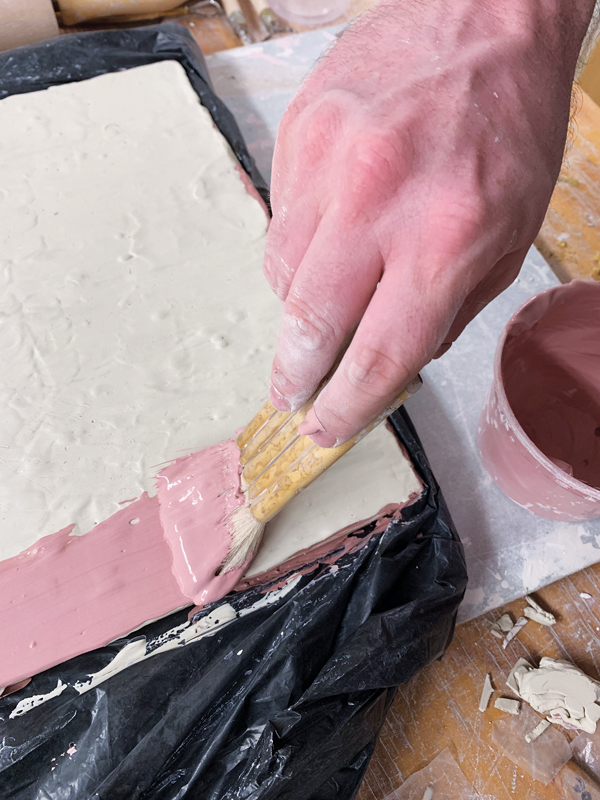 1 Apply alternating layers of red and white slip to a slab and leave to firm up.